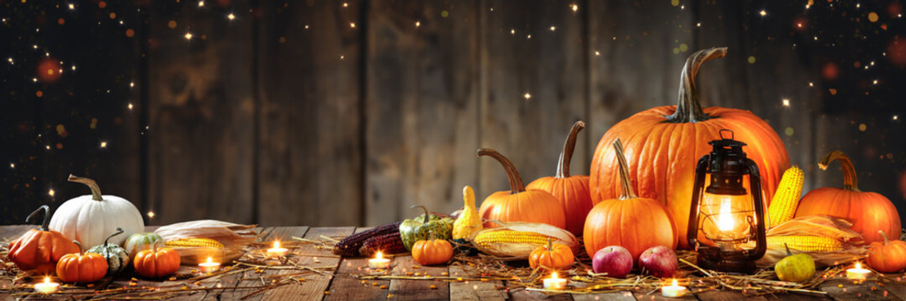 Wisconsin fall harvest table with pumpkins, apples, corn, and a glowing lantern for Thanksgiving gifting.