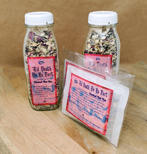 Til Death Do Us Part Tub Tea (Death & Decay Fragrance): the image depicts two glass bottles similar to old glass milk bottles, placed on a wooden surface in front of a brown background and filled with dried herbal and floral ingredients. A piece of cloth (the reusable steeping pouch) is packed into the top of each clear bottle and visible on top of the contents. The label on the front of the bottles reads, "Til Death Do Us Part Tub Tea". In front of them are fabric pouches (sachets) containing the same product in single-use portions.