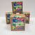 A stack of four mystery boxes, three arranged on the bottom with a fourth resting on top. Brown kraft paper boxes with very colorful labels.