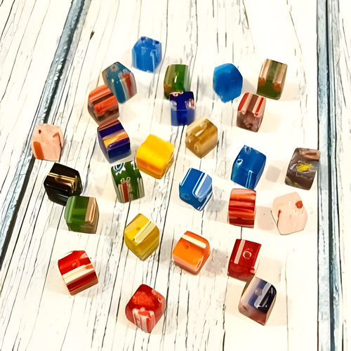 A diverse collection of colorful crafting beads and jewelry-making supplies spread out against a white background.