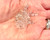 A close-up photograph shows a small pile of clear, transparent glass or crystal seed beads resting in the palm of an open hand.