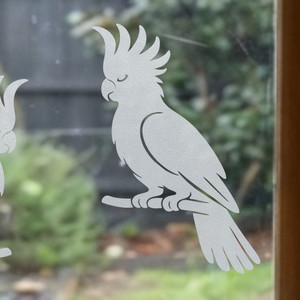 Close-up of a left-facing frosted Cockatoo window cling clinging to glass, showing etched-glass texture and soft matte finish.