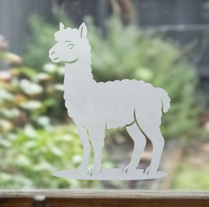 Close-up of a left-facing frosted Alpaca window cling clinging to glass, showing etched-glass texture and soft matte finish.