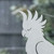 Close-up of a frosted Cockatoo window cling clinging to glass, showing etched-glass texture and soft matte finish.