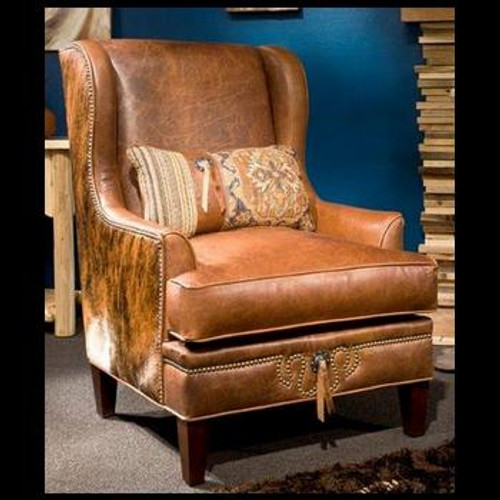 Rustic leather wingback armchair with cowhide sides and decorative pillows