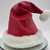 Red leather Santa hat with white shearling trim worn on a model