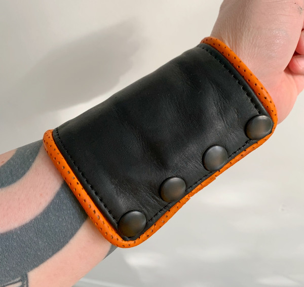 Black Leather Wrist Wallet with Perforated Orange Leather Piping by Restrict Gear — product image 1