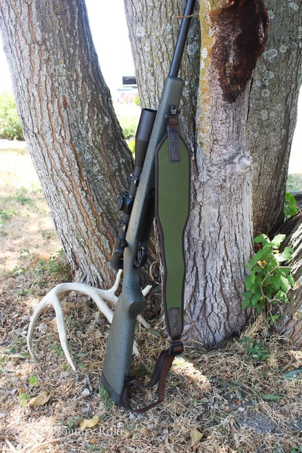 HCR Vero Vellini Rifle Sling in Green, hanging on a tree branch for outdoor hunting use.