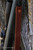 HCR Murray Leather HCR Rifle Sling in Brown, close-up of the leather rifle sling attached to a rifle against a tree trunk.