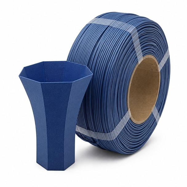 Matte dark blue 3D printer filament roll standing on edge with a matching dark blue 3D printed vase placed in front on a white background.