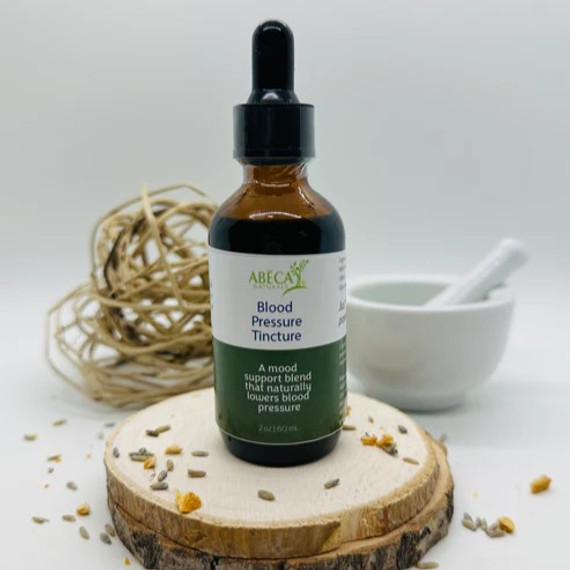 Abeca Naturals Blood Pressure Tincture 2 oz bottle, an herbal blend with lemon balm and yarrow, displayed on a wooden slice with natural decor in the background