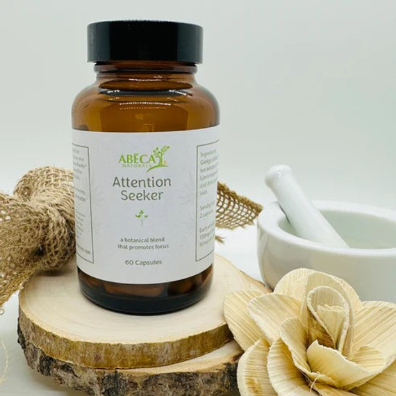 Abeca Naturals Attention Seeker Capsules 60-count bottle, a botanical blend with ginkgo, green tea, L-theanine, lion’s mane, and ashwagandha for focus and mental clarity, displayed on a wooden slice with natural decor. Abeca Naturals Attention Seeker Capsules 60-count bottle, a botanical blend with ginkgo, green tea, L-theanine, lion’s mane, and ashwagandha for focus and mental clarity, displayed on a wooden slice with natural decor.