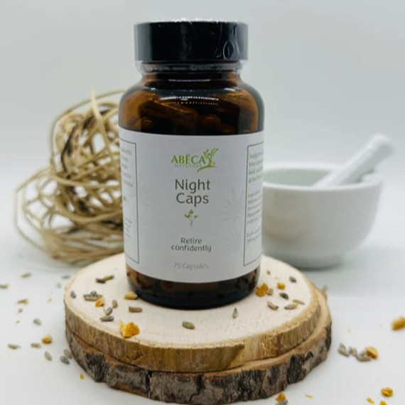 Abeca Naturals Night Caps 75-count bottle, herbal sleep support capsules with valerian, hops, and passionflower, displayed on a wooden slice with lavender buds, citrus peel, and natural decor Abeca Naturals Night Caps 75-count bottle, herbal sleep support capsules with valerian, hops, and passionflower, displayed on a wooden slice with lavender buds, citrus peel, and natural decor