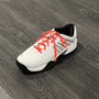 White shoebeze on a shoe with a baseball bat charm