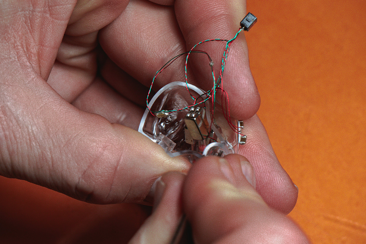 64 Audio engineer building a custom IEM by hand with soldering iron