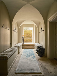 David Rockwell Splash Sea Runner in a vaulted boot room hallway with cushioned benches, wellington boots and stone steps
