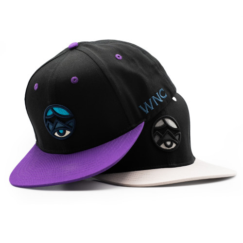 WNC World Needs Cannabis snapback hat pictured in black with color logo and purple bill, and black with grey logo and grey bill