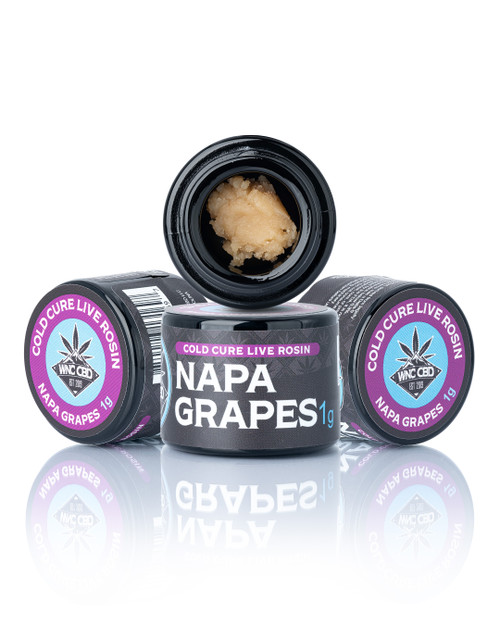 Napa Grapes Cold Cure Live Rosin in black container, beige budder consistency, "WNC CBD" and "Napa Grapes 1g" labels visible.