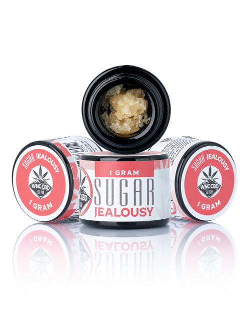 Jealousy Sugar (85.700% THCa) crumble in black jar with red and white label design, 1 gram. Jealousy Sugar (85.700% THCa) crumble in black jar with red and white label design, 1 gram.