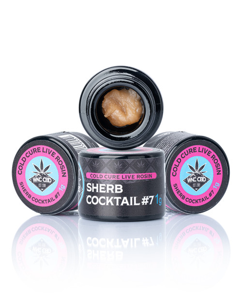 Sherb Cocktail #7 Cold Cure Live Rosin in black jars with beige rosin, pink and blue labels, and WNC CBD branding.
