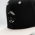 Close up of WNC World Needs Cannabis snapback hat pictured in black with grey logo and grey bill