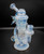 JDZ x Chaka Ice Blooper glass pipe with swirling blue and white patterns, intricate design, and sturdy base. JDZ x Chaka Ice Blooper glass pipe with swirling blue and white patterns, intricate design, and sturdy base.