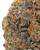 Close up of a dense Zoap cannabis bud displaying forest green and dark purple hues, amber pistils, and a thick layer of frosty white trichomes 