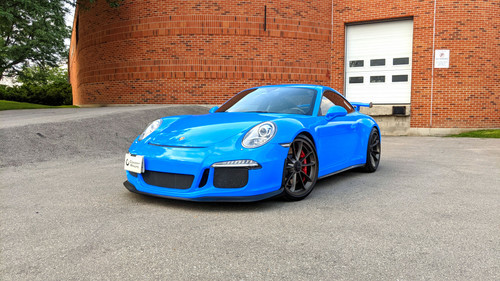 A luxurious Porsche, wrapped in KPMF's Gloss Atlantic Pearl vinyl, radiates elegance and sophistication. The vibrant blue color with a pearlescent sheen glistens under the sunlight, highlighting the car's sleek silhouette and aerodynamic design. The gloss finish provides a high-shine effect that enhances the vehicle's contours, from the sculpted hood and fenders to the smooth curves of the roof and rear. The wrap's impeccable application demonstrates its superior conformability, adhering flawlessly to every curve and edge. This captivating transformation underscores the premium quality and stunning visual impact of the KPMF Gloss Atlantic Pearl vinyl wrap.