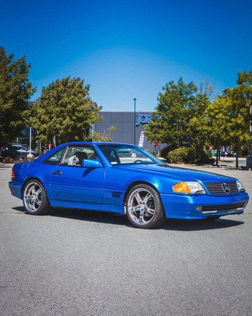 A 1990 Ford Mustang wrapped in KPMF K75400 Gloss Indulgent Blue vinyl exudes a striking, modern look. The car's body showcases the iridescent blue color, enhanced by the glossy, candy-like finish that glistens under sunlight. The metallic sheen adds a layer of sophistication, giving the classic Mustang a refreshed and contemporary appearance. The wrap adheres seamlessly to the car's contours, highlighting the Mustang's iconic lines and curves while providing a durable, high-quality finish that stands out on the road.