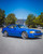 A 1990 Ford Mustang wrapped in KPMF K75400 Gloss Indulgent Blue vinyl exudes a striking, modern look. The car's body showcases the iridescent blue color, enhanced by the glossy, candy-like finish that glistens under sunlight. The metallic sheen adds a layer of sophistication, giving the classic Mustang a refreshed and contemporary appearance. The wrap adheres seamlessly to the car's contours, highlighting the Mustang's iconic lines and curves while providing a durable, high-quality finish that stands out on the road.