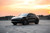 A Porsche SUV detailed in KPMF K75530 Satin Perfect Black vinyl wrap, emphasizing the elegant, understated finish that perfectly complements the sleek design of luxury vehicles.