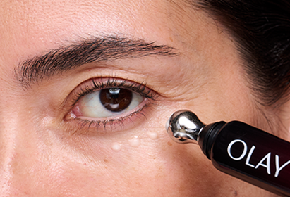 Close up image of a woman applying Olay Eye Wrinkle Correcting Treatment under the left eye