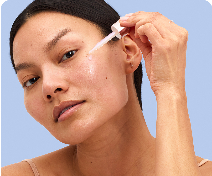 Confident woman applying Olay Super Cream for multi-benefit skin care with advanced ingredients on her cheek while holding the dropper