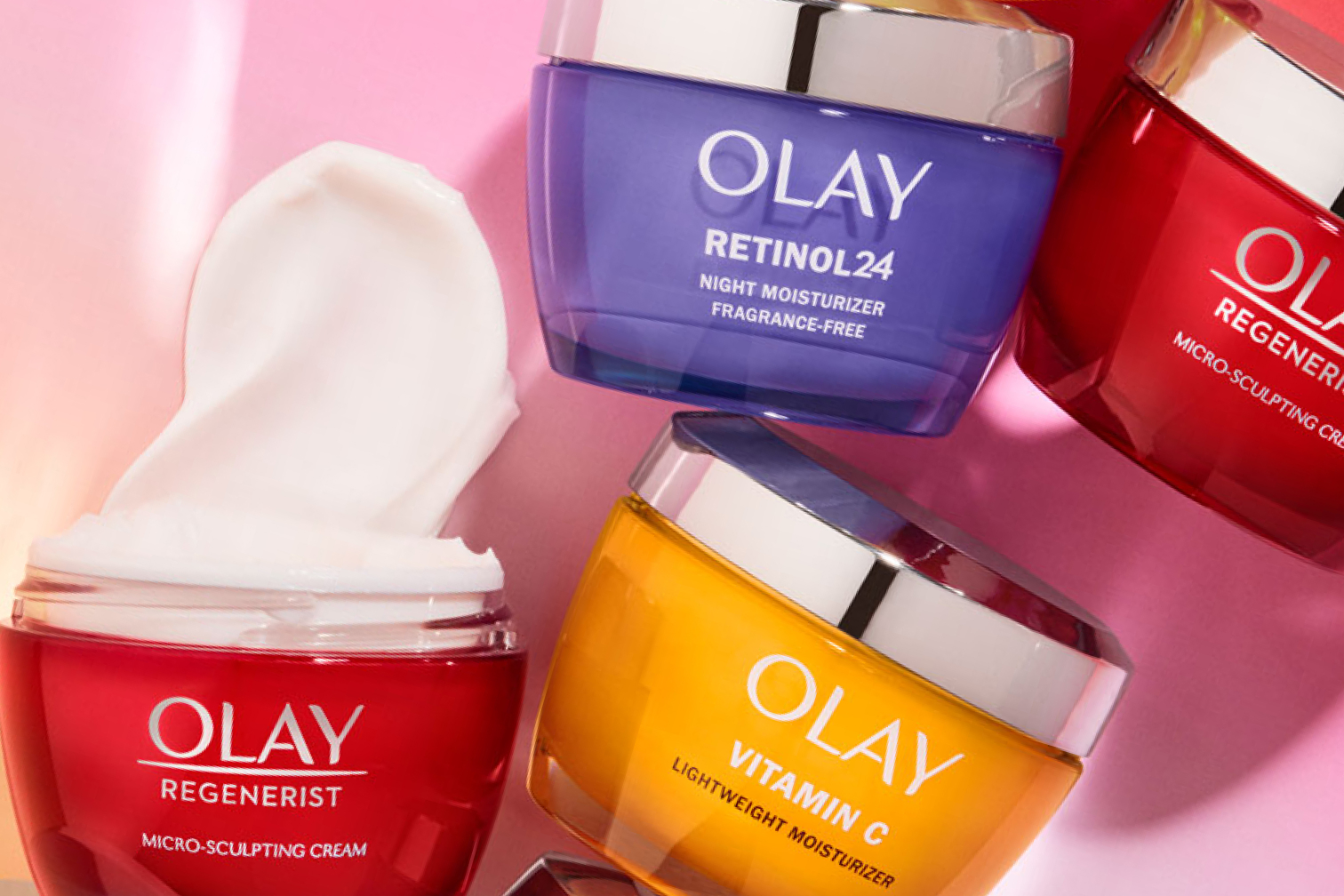 Olay micro sculpting cream without a lid and moisturizer spread out above it. Olay Retinol 24 and Vitamin C moisturizer jars are beside it.