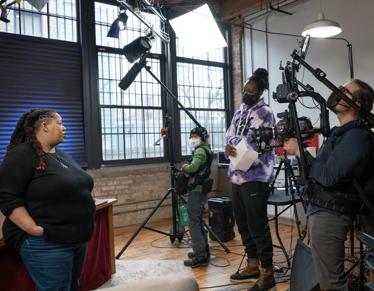 Video production set with the crew facing the female interviewee