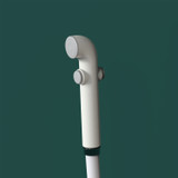 Brondell PureSpa essential hand-held bidet sprayer in front of a green background