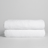 Two Nebia Bath Towels White in a light gray background