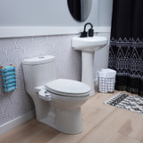 Omigo Element bidet attachment in white, installed in a modern bathroom with black and white accents and turquoise bidet towels at the ready