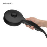 Brondell Nebia Yuba 5-Setting Handshower with hand holding the Matte Black HaloNetic Double Docking System displaying rear of showerhead with pause mode button.