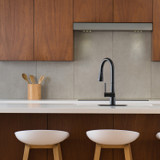 Brondell Jema Touchless Pull-Down Kitchen Faucet in matte black, showcased in a modern kitchen with wood cabinetry, a clean white countertop, and minimalist décor for a sleek contemporary look.