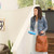 Woman holding blue Brondell GoSpa Advanced Travel Bidet GS-84/85 getting ready to exit the house with handbag