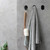Nebia Multi-Purpose Hook Set Matte Black three pieces in use holding a towel and a loofah in front of a  gray background