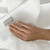 A hand touching a Nebia Hand Towel White