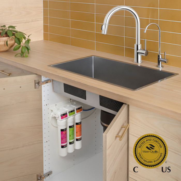 Coral UC300 Three stage under sink carbon block water filtration system installed.  Water Quality Association Gold Seal Certified logo in corner.
