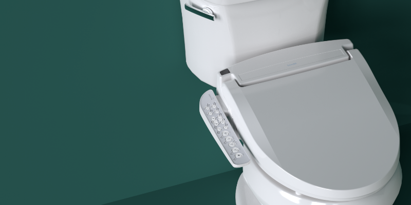 bidet toilet seat with sidearm installed against a forest green wall