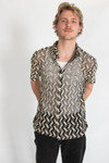 Man wearing black and white zigzag knit shirt