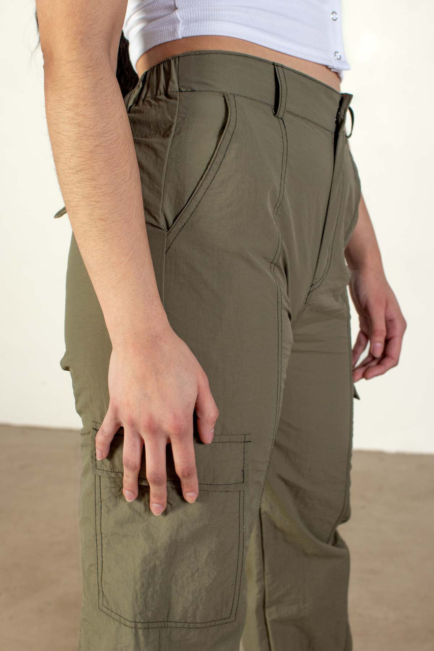 a man wearing khaki pants and a green shirt and white shoes Stock Photo by  Icons8