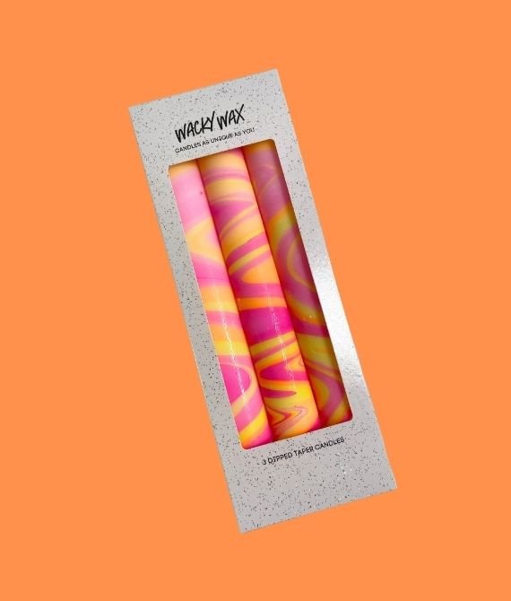 Three neon hand marbled candles in pink, orange, and yellow, in a foiled gift box.