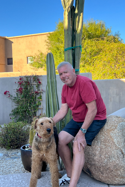 A picutre of an Airedale Terrier sitting with her Dad in the Southwest