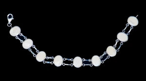 This trendy round mammoth ivory is inlayed into an elegant oval shaped sterling silver bracelet.  This bracelet has two sterling silver links in between the oval mammoth pieces.  The dimension of the bracelet is approximately 7.2" x .49".
